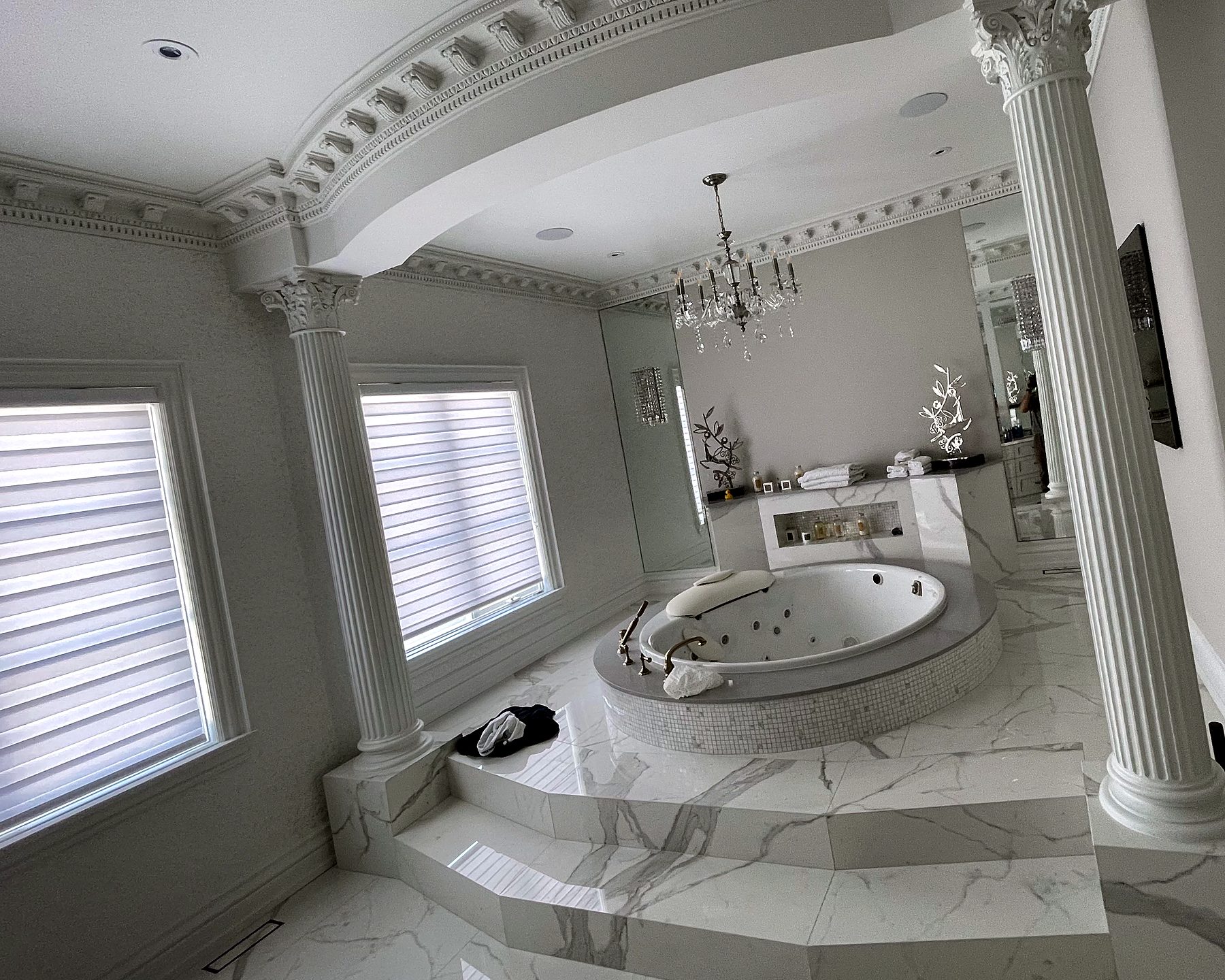 Marble ensuite with columns and sheer shades with horizontal fabric vanes