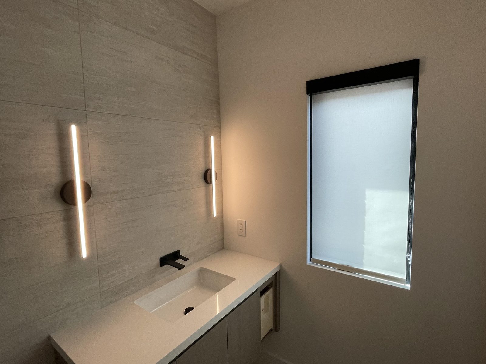 Bathroom with a white light-filtering roller shade in a black cassette