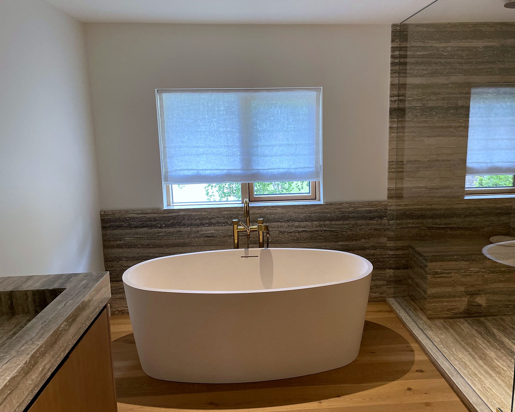 Ensuite with a freestanding tub and a linen Roman shade