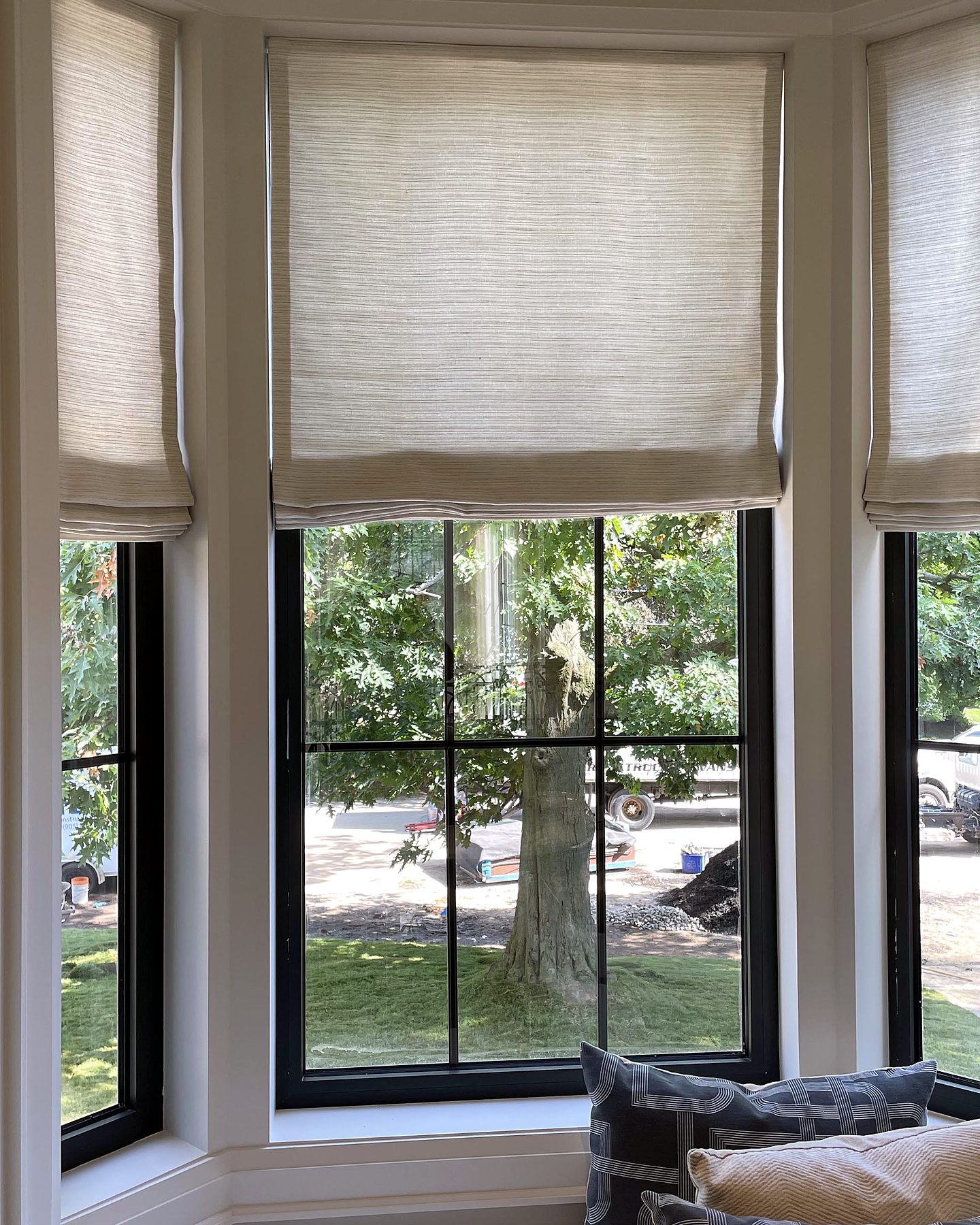 Bay window with three linen Roman shades