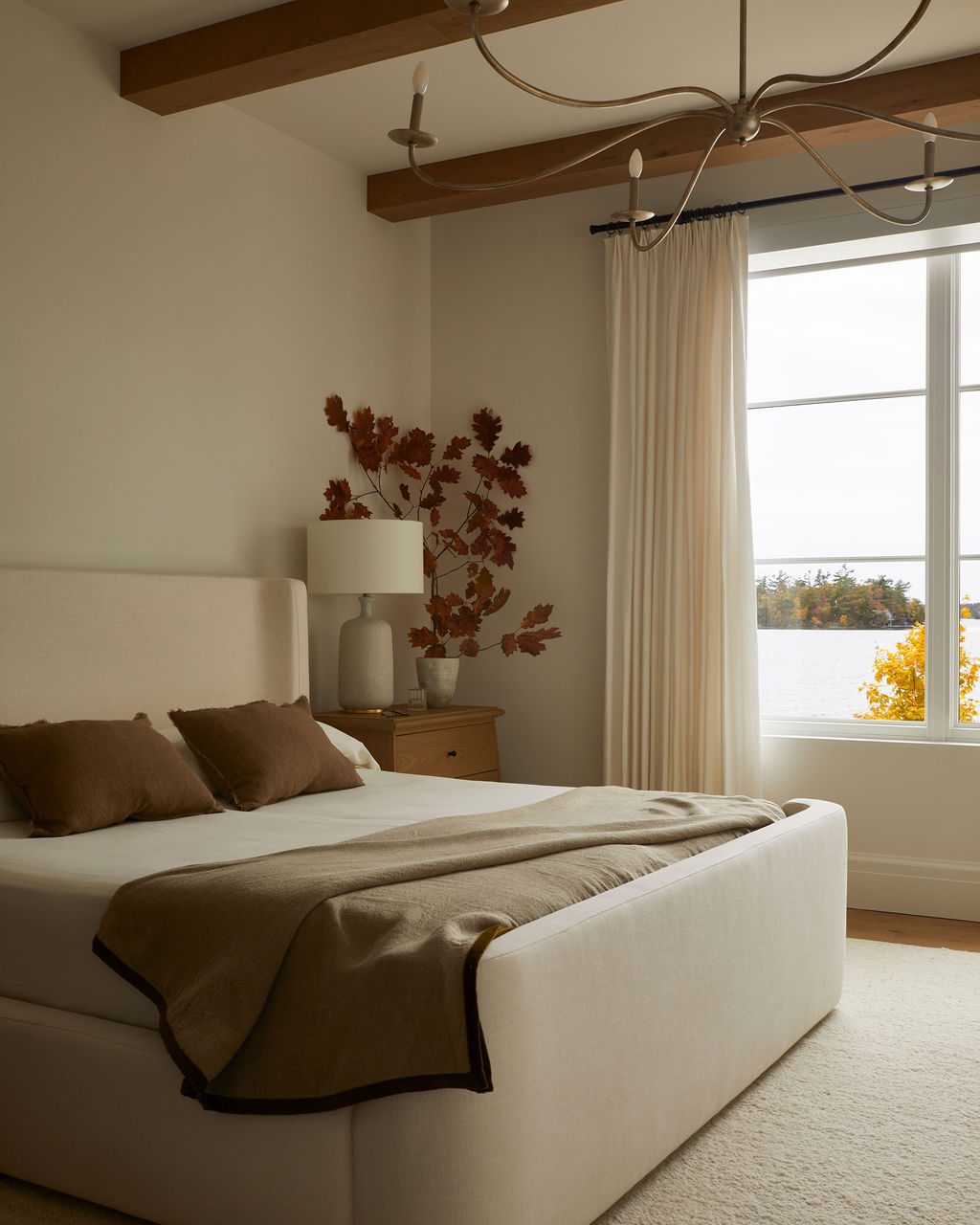 Guest bedroom with lined linen drapery drawn back to an autumn view