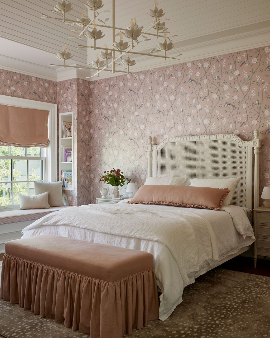 Bedroom with a blush Roman shade above a window seat