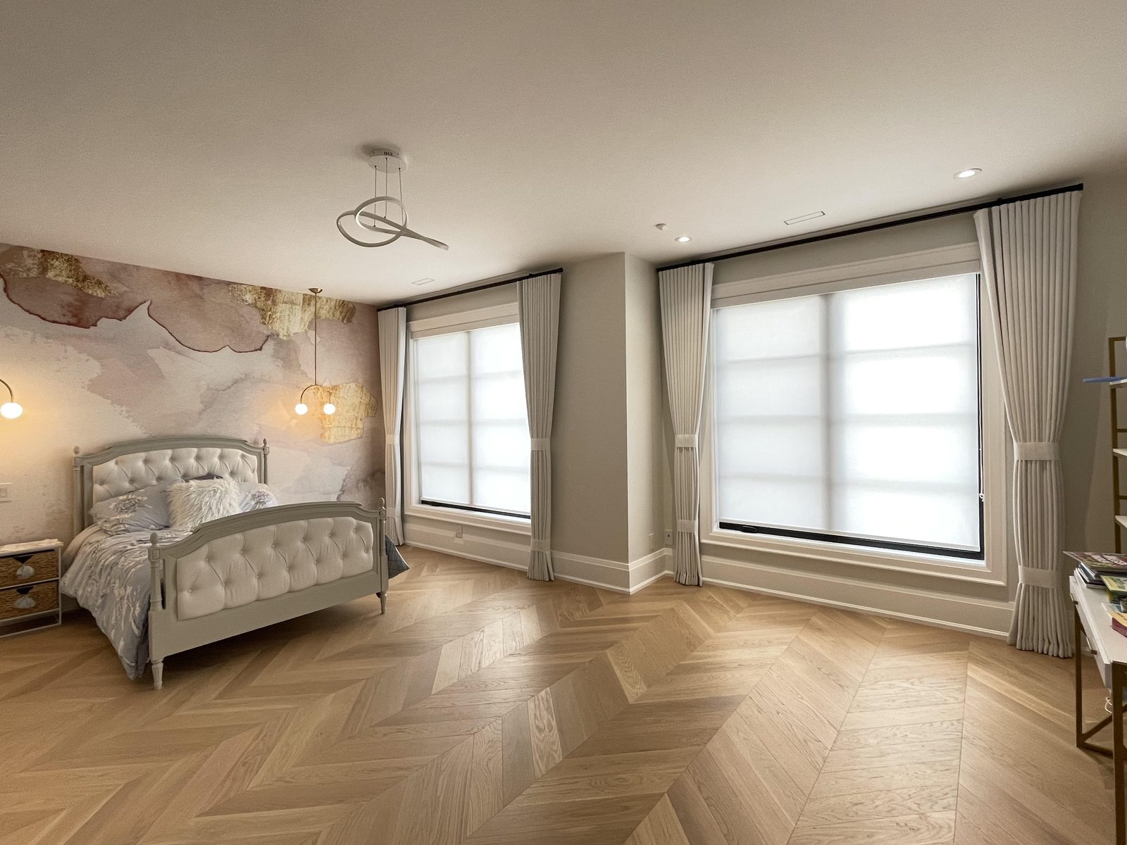 Bedroom with drapery panels tied back over light-filtering roller shades