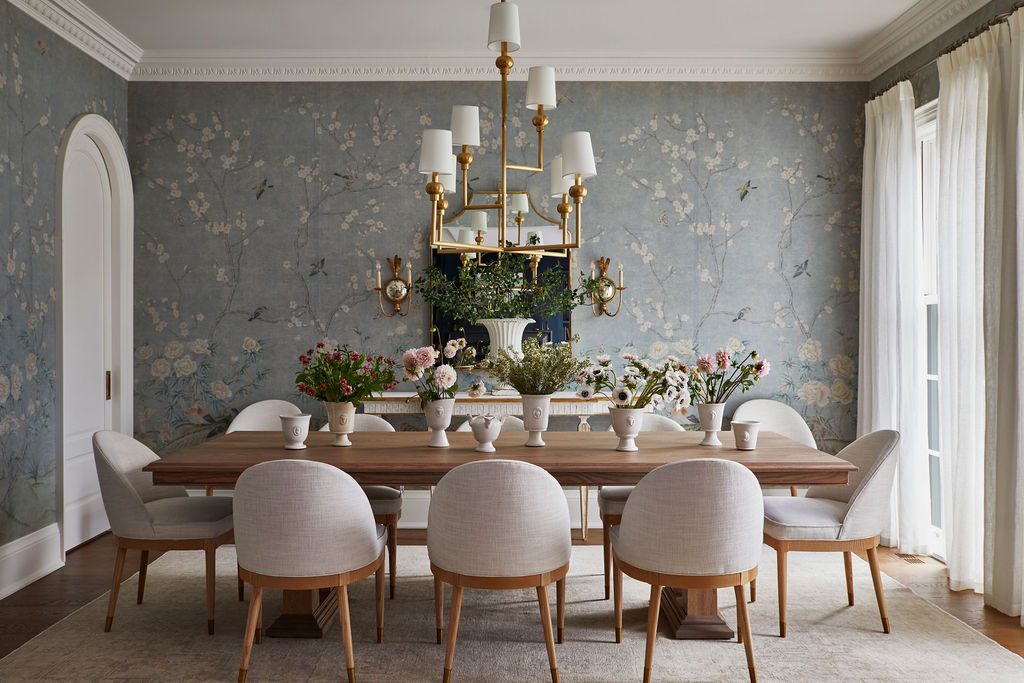 Dining room with blue chinoiserie wallpaper and ivory sheer panels at the far window