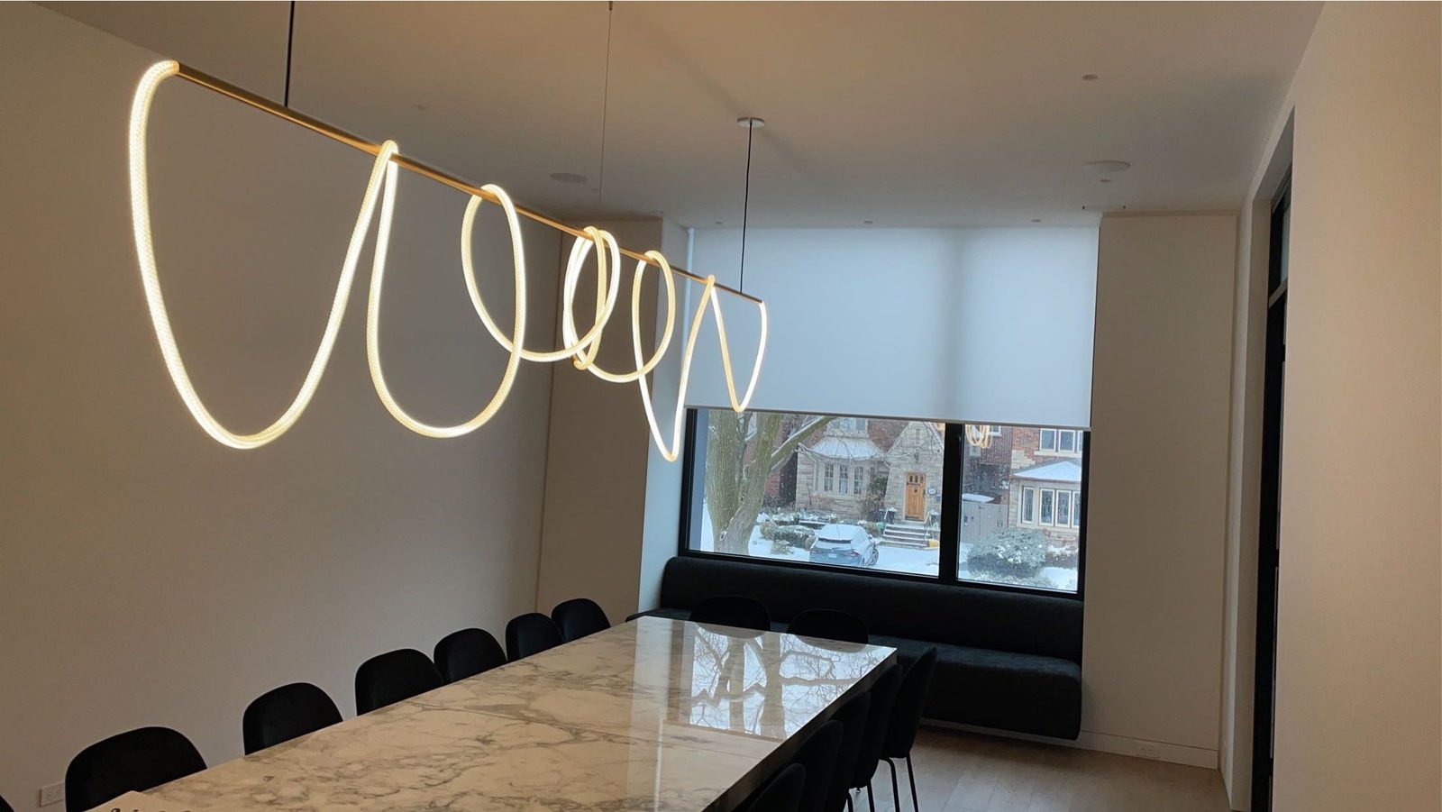 Dining room with roller shade, sculptural pendant