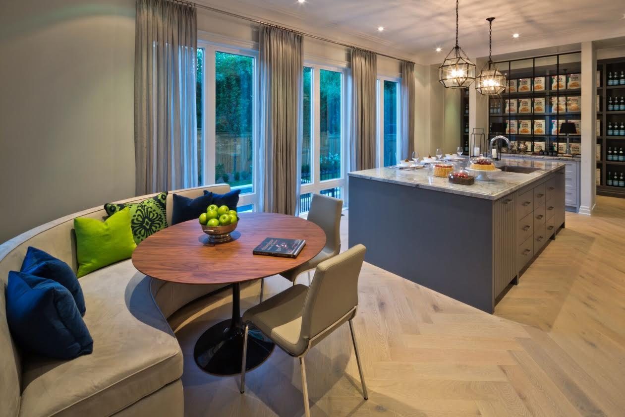 Breakfast nook beside a kitchen island with taupe pleated drapery panels on a rod