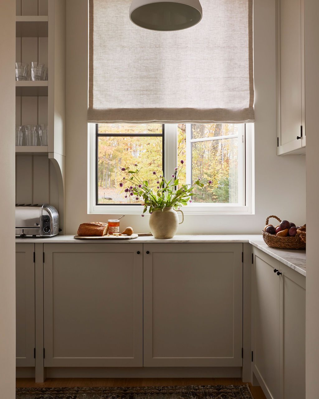 Kitchen with a relaxed linen Roman shade over the sink