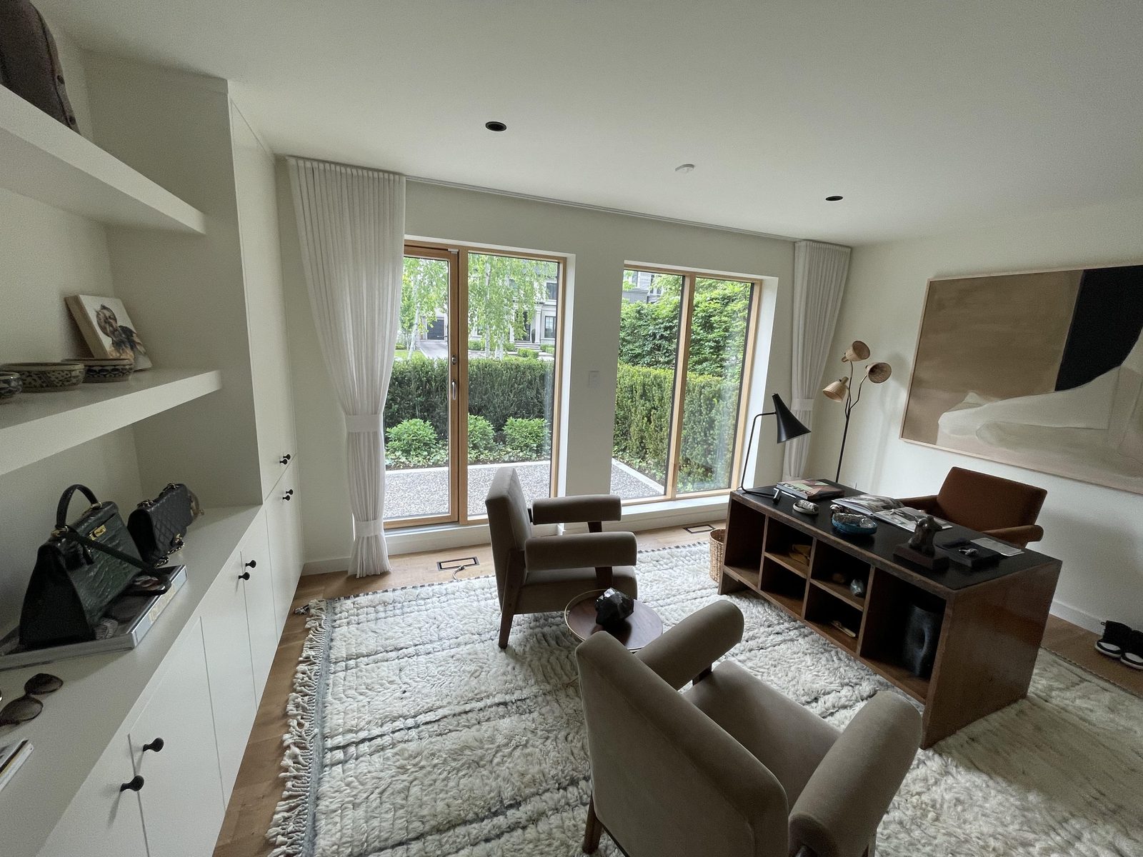 Home office with white sheer panels tied back at the garden door